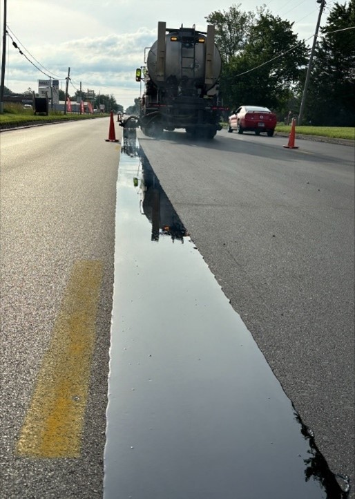 VRAM, a thick band of asphalt, is being shot from a truck on the centerline of a road