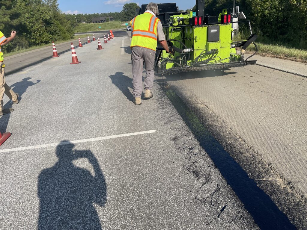 Man guiding the spray application of J-Band on the track