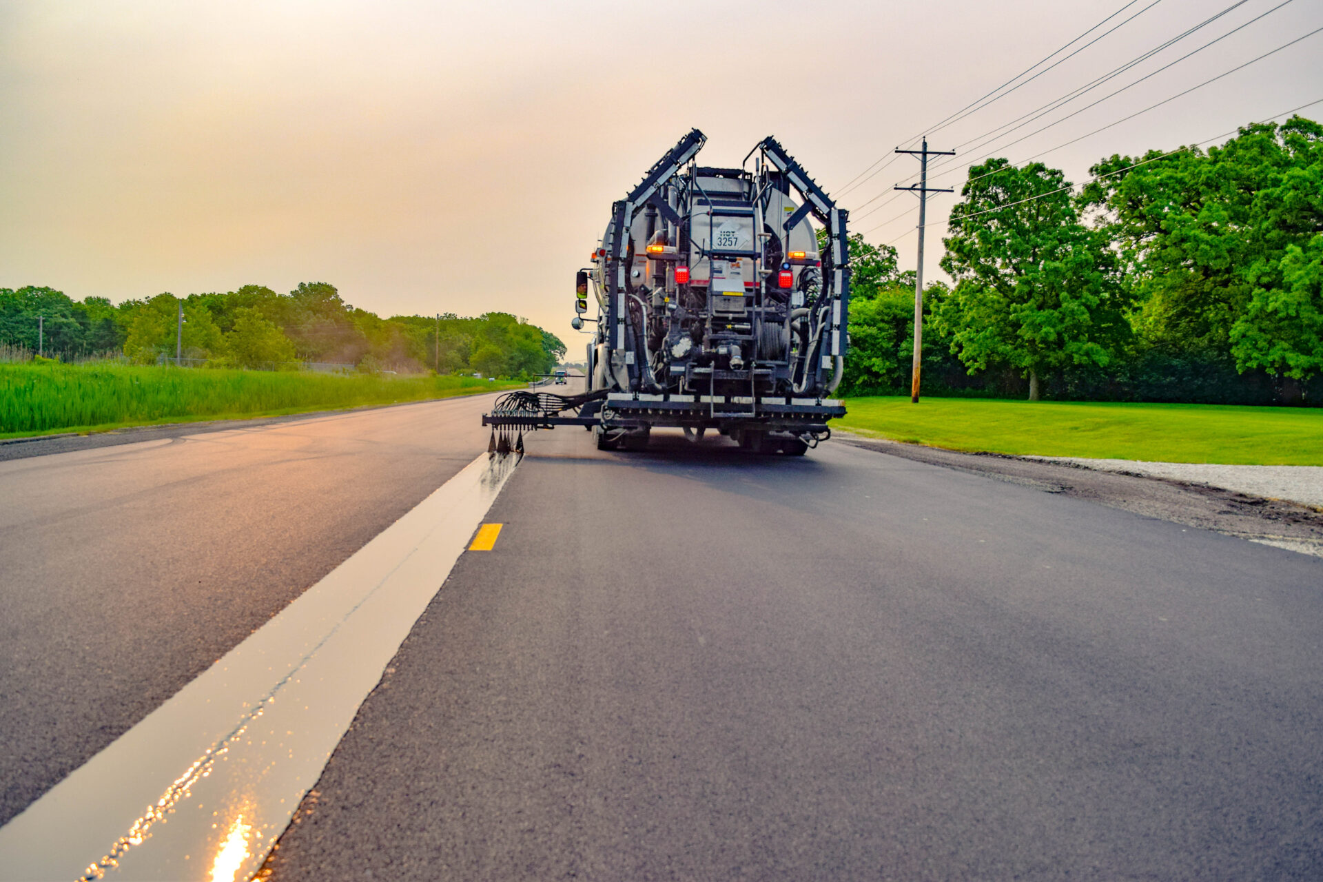 Truck drives down the road, spraying J-Band on the centerline